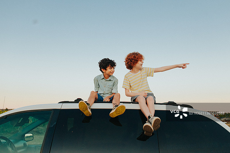 两个年轻的白人兄弟坐在一辆货车顶上图片素材