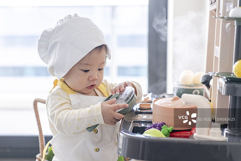 忙碌的婴儿小厨师可爱神态图片素材