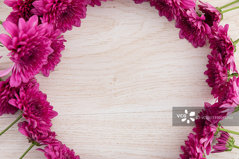 粉红色的花在木制的背景上围成一个圈图片素材