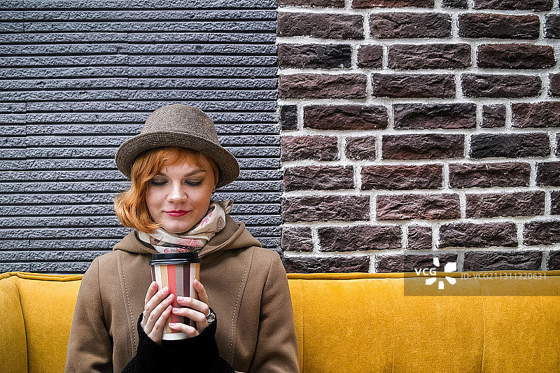 年轻女子坐在户外喝着咖啡，俄罗斯图片素材