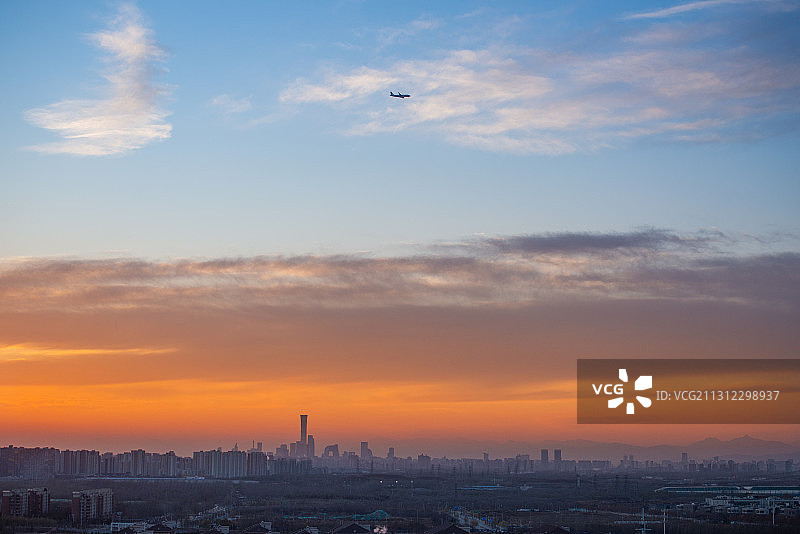 傍晚飞回北京的一架飞机划过双色的天空图片素材
