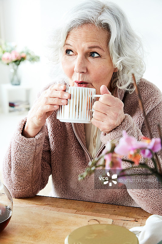 一位年长妇女喝着茶的肖像图片素材