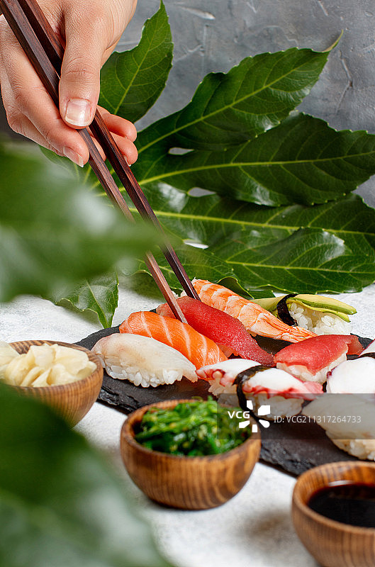 用筷子从盘子里拿寿司的手的特写图片素材