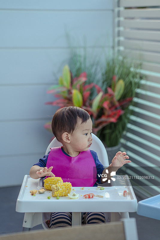 健康宝宝在婴儿餐桌上按时就餐图片素材