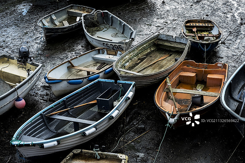 英国，低潮时停泊在港口的渔船的高角度视图。图片素材