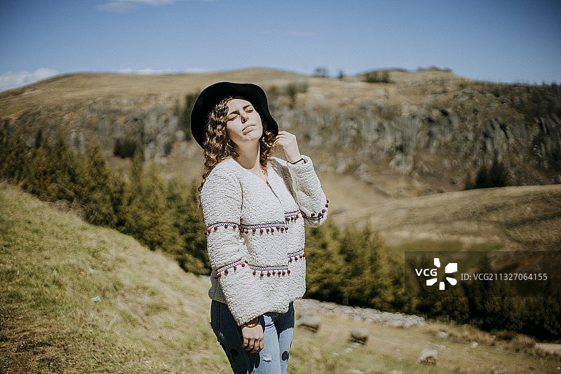 美丽的年轻女人在户外的草山，秘鲁图片素材