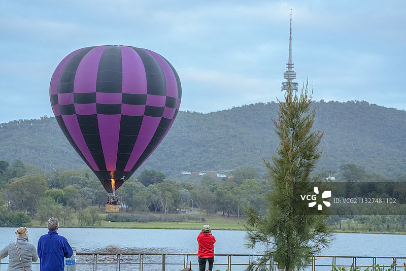 游客眺望远处山林半空中的热气球图片素材