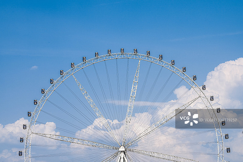 蓝天白云下游客在欢乐谷游乐场乘坐摩天轮图片素材