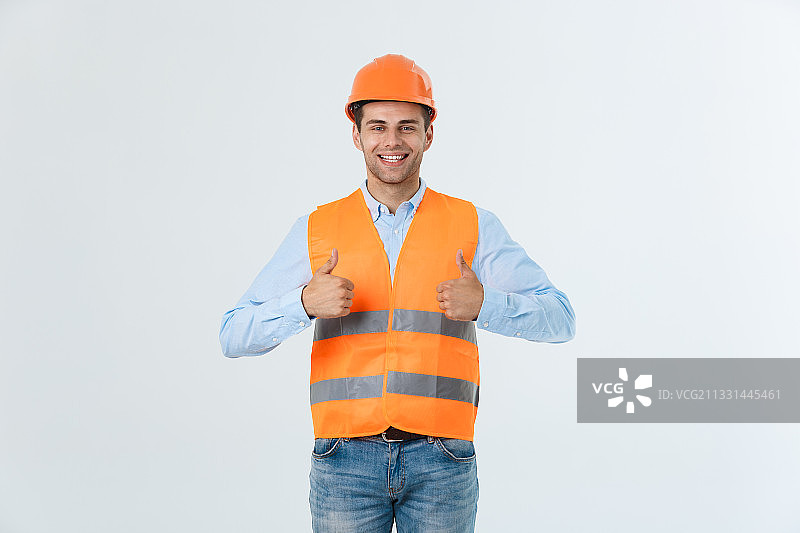 微笑的工程师在白色背景下竖起大拇指的肖像图片素材
