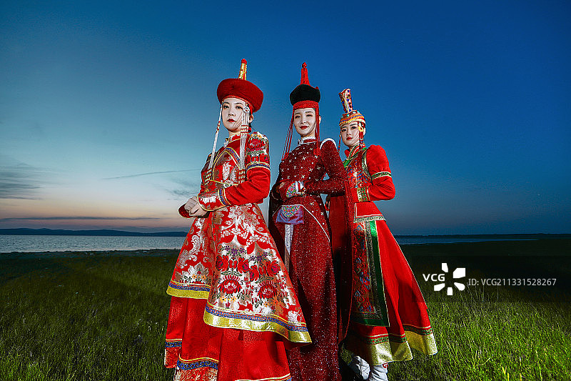 草原上穿着蒙古族传统服饰的亚洲年轻女性们图片素材