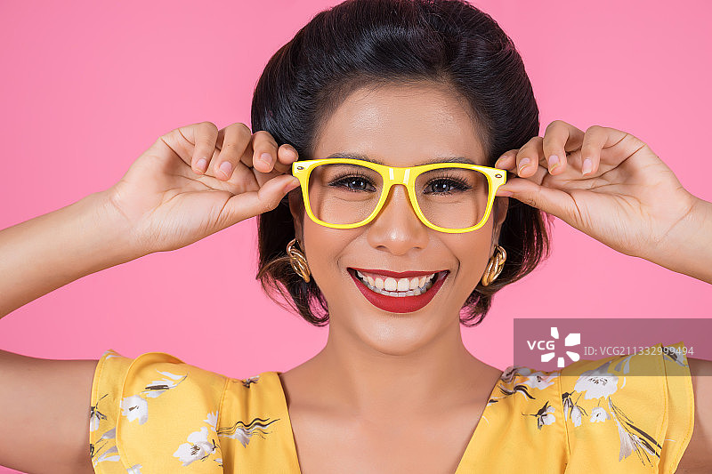 微笑的女人的肖像戴着眼镜的粉红色的背景图片素材