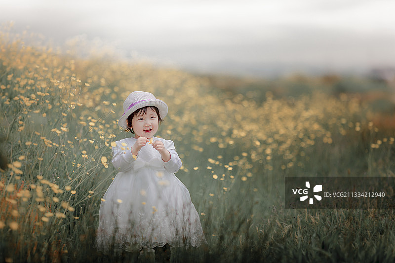 可爱的女孩站在鲜花中的田野，温哥华，不列颠哥伦比亚省，加拿大图片素材