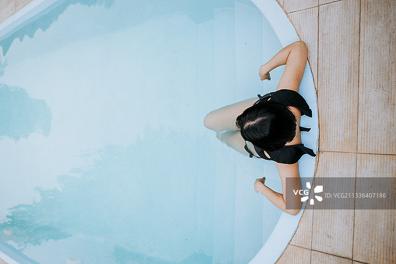高角度的女人坐在游泳池，卢林，秘鲁图片素材
