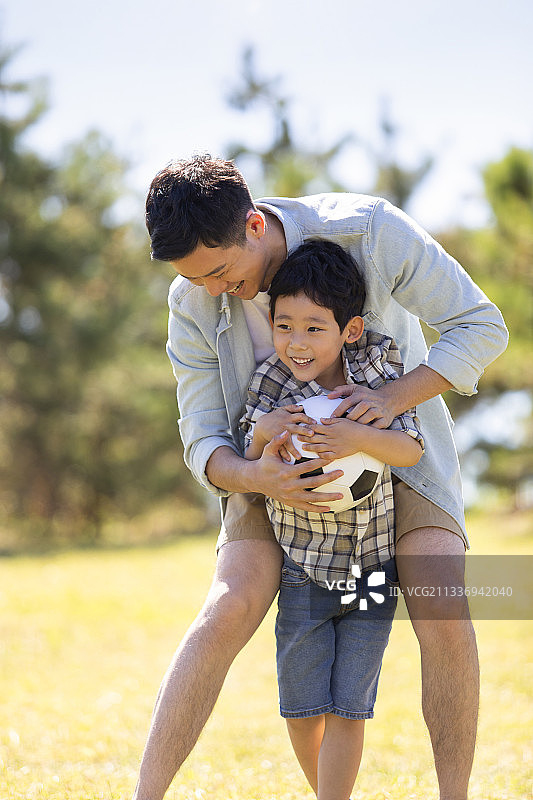 快乐的父子俩在草地上玩耍图片素材