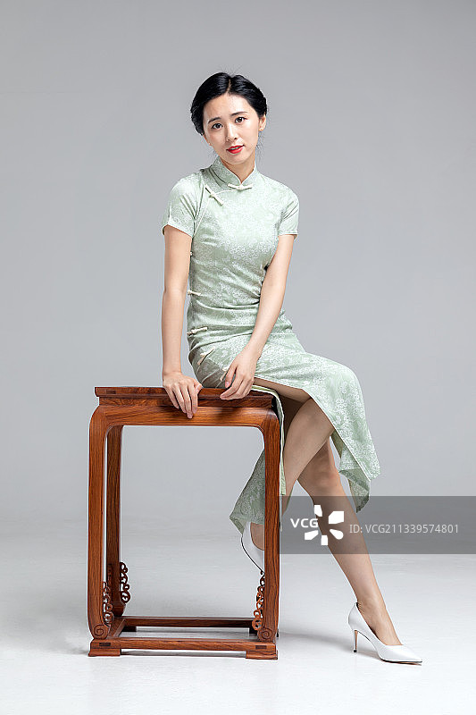 坐在椅子上穿旗袍的亚洲女性图片素材