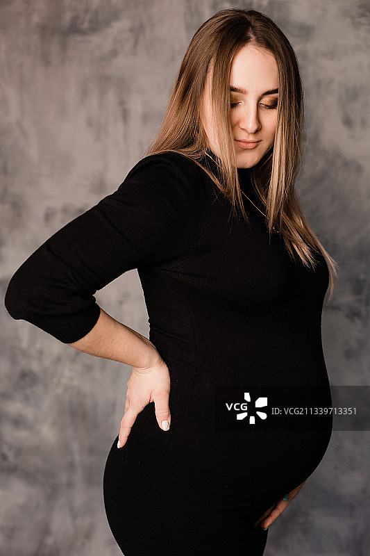 俄罗斯孕妇靠墙站着的侧视图图片素材