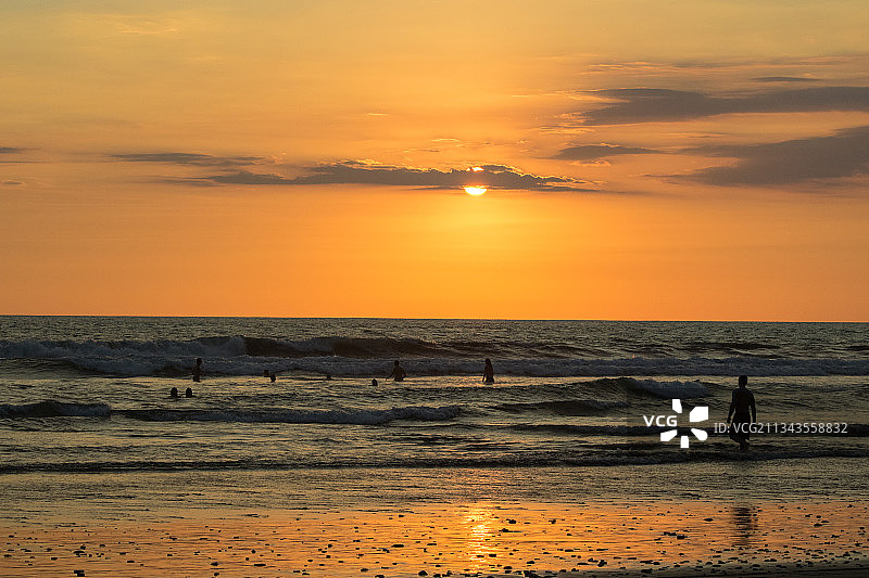 哥斯达黎加蓬塔雷纳斯省瓜卡利略海滩，日落时海滩上人们的剪影图片素材