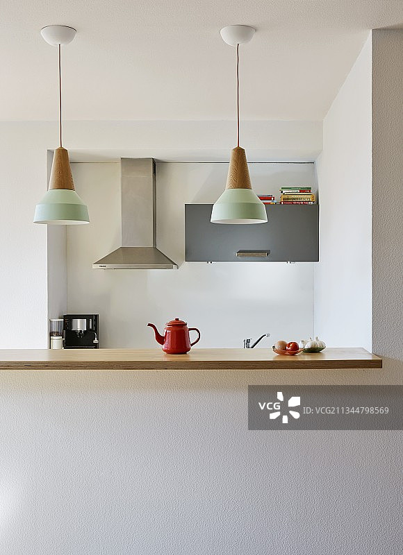 厨房柜台与木制工作台面下排吊灯在开放式，极简厨房图片素材
