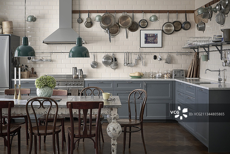 厨房柜台上方的架有灰色子上挂着平底锅，还的橱柜和餐桌图片素材