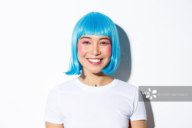 微笑的年轻女子的肖像与蓝色的头发在白色的背景图片素材