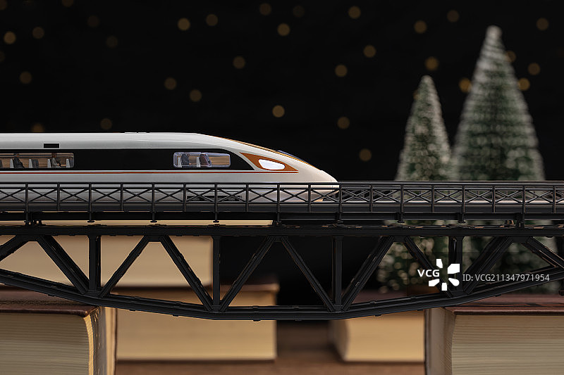 微缩创意书本高架桥上行驶的高铁动车与旅客图片素材