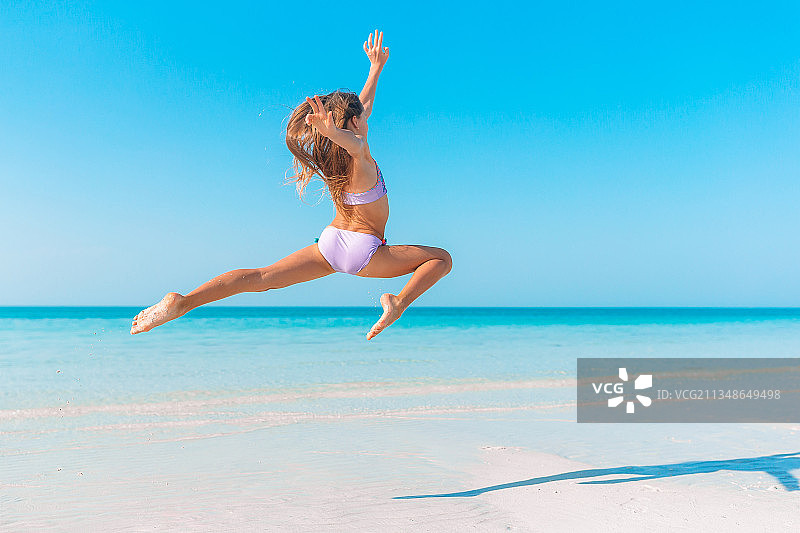 女孩在海滩上跳跃图片素材