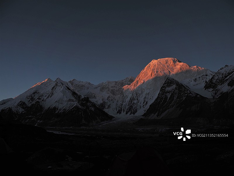 中国新疆伊犁，白雪皑皑的雪山在晴朗的天空下的风景图片素材