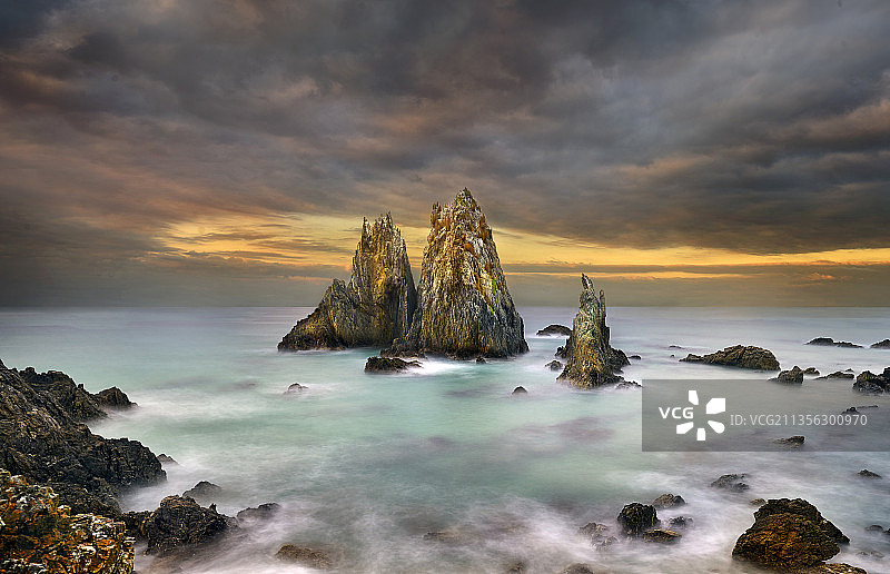 日落时，海中岩石与天空的风景图片素材