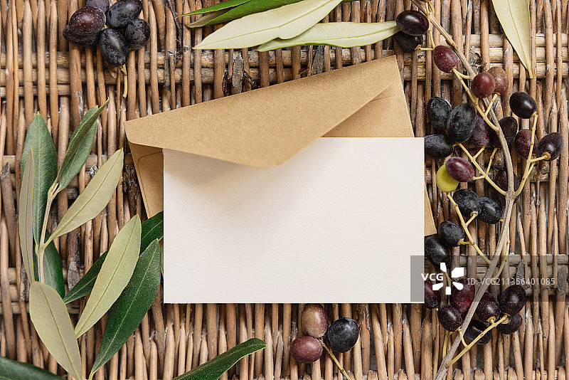 空白卡片和信封在木头和橄榄树树枝图片素材