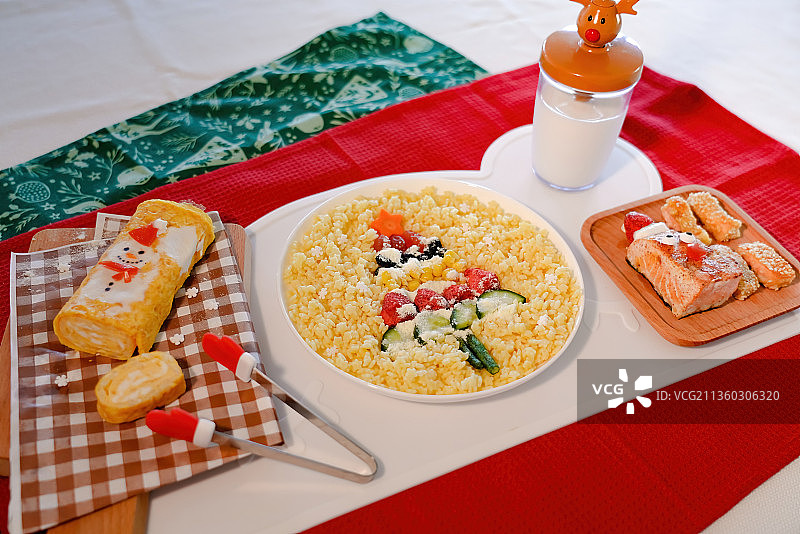 红色餐垫上的圣诞老人星星意面三文鱼厚蛋烧牛奶套餐图片素材