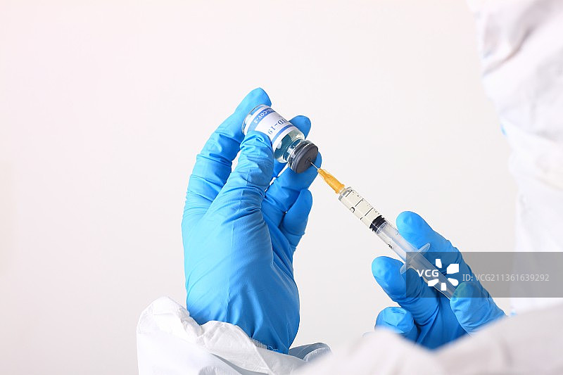 身穿防护服的医生手拿新冠疫苗注射器图片素材