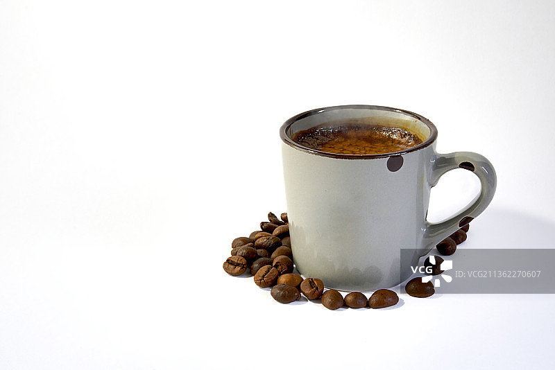 咖啡的浓缩咖啡杯，特写的咖啡杯与豆子在白色的背景图片素材