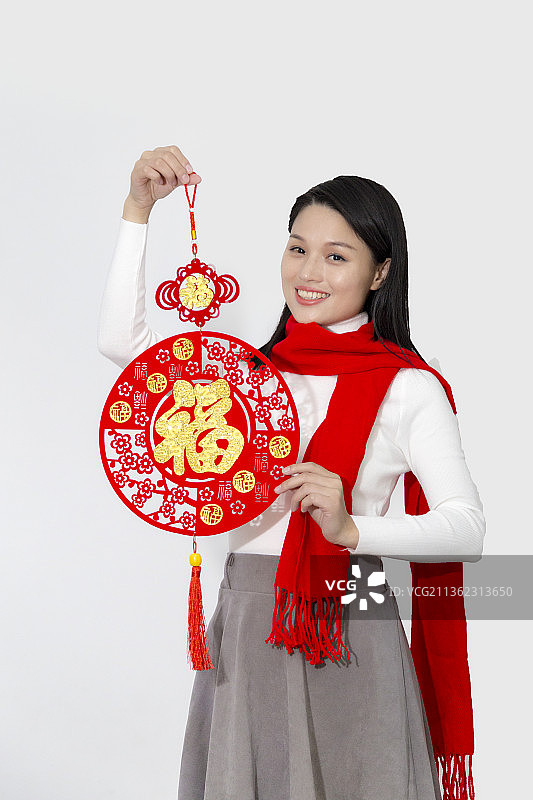 拿着春节装饰挂件的长发东方女人图片素材