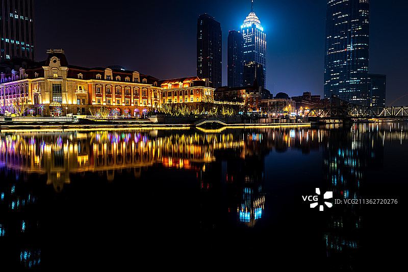 夜晚拍摄中国天津海河边的高楼大厦和津湾广场倒影图片素材