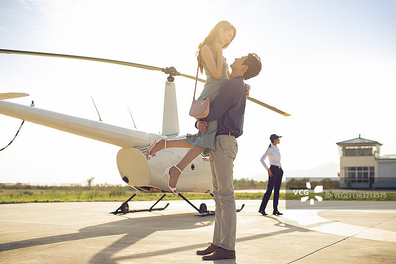 年轻情侣乘坐直升机旅行图片素材