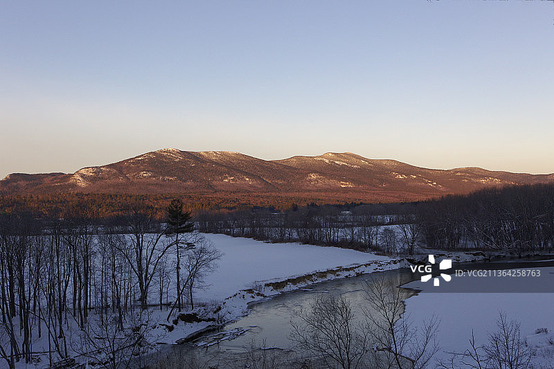 清晨破晓，在美国新罕布什尔州康威，白雪皑皑的山峦映衬着清澈的天空，风景如画图片素材