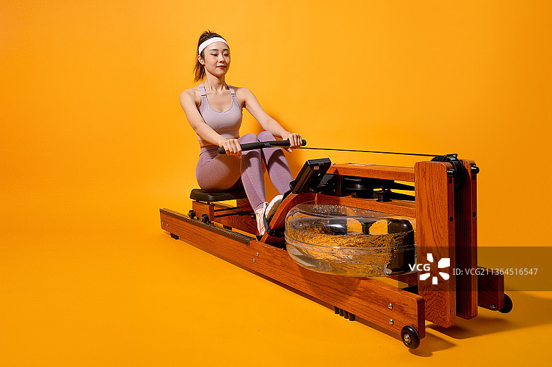 时尚运动美少女在使用划船机图片素材