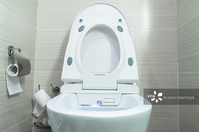 中国家庭室内装修设计，厕所里的智能水洗马桶和悬挂在墙壁上的操作按键面板图片素材
