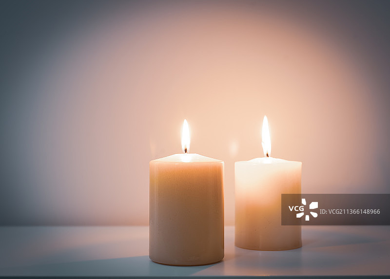 库存照片，照明蜡烛在桌子上靠墙的特写图片素材