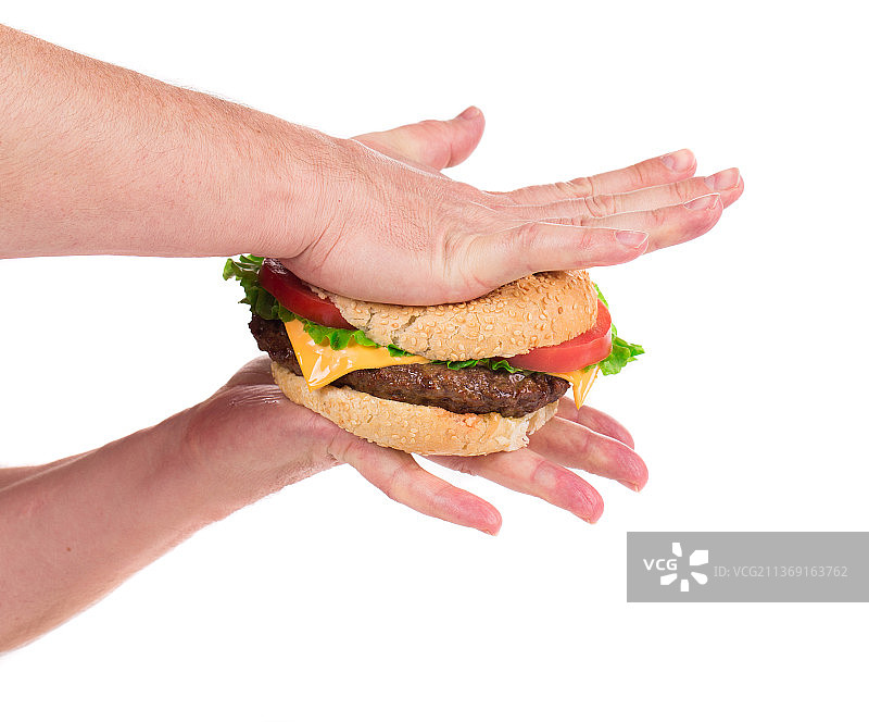 摩尔多瓦，双手压着多汁的汉堡，白色背景下拿着汉堡的妇女裁掉的手图片素材