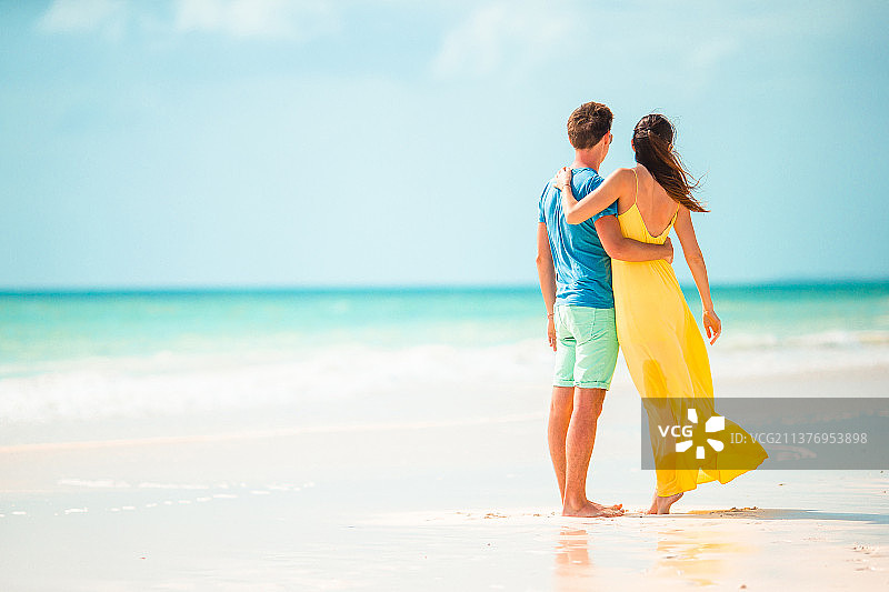 一对年轻夫妇在白沙滩上度过暑假图片素材