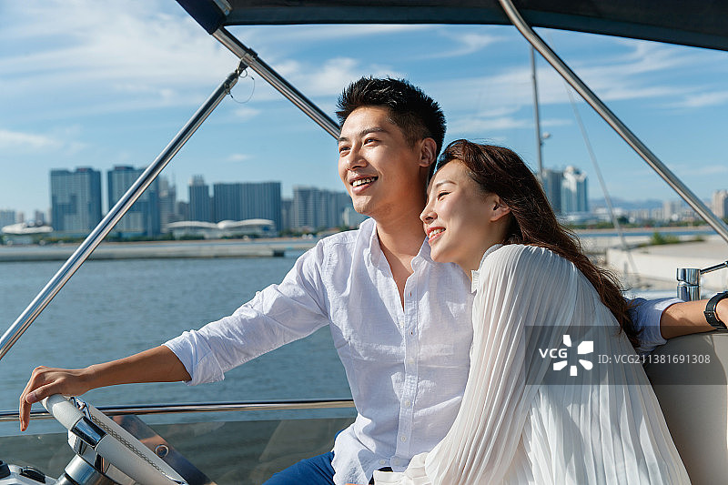 浪漫的青年夫妇驾驶游艇出海图片素材