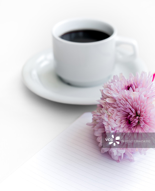 粉红色的花与咖啡杯在桌子上的特写图片素材