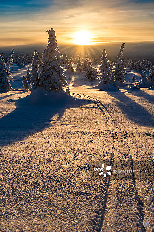 芬兰，罗瓦涅米，日落时被雪覆盖的土地对着天空的风景图片素材