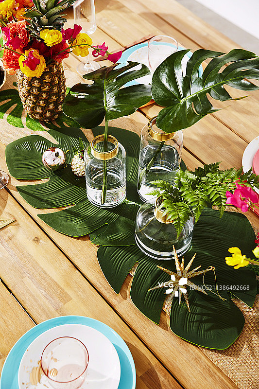 菠萝花瓶中的花束和玻璃花瓶中的叶子在圣诞节装饰桌子图片素材