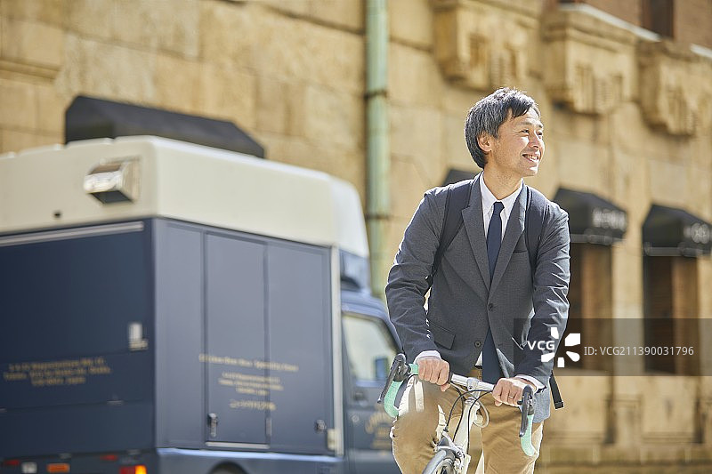 骑自行车的中年日本商人图片素材