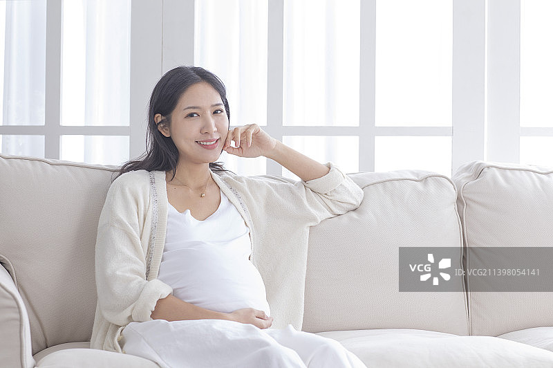 孕妇手摸肚子坐着休息图片素材