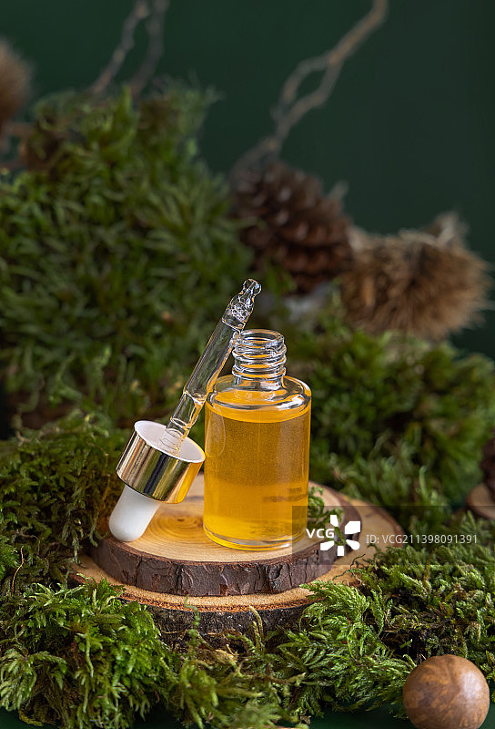 打开滴瓶，黄色液体接近绿色苔藓，接近天然化妆品图片素材