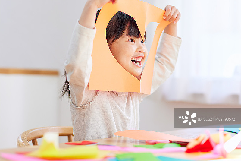一个日本小孩在家里玩折纸图片素材