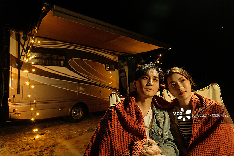 夜晚在房车旁露营的青年伴侣图片素材